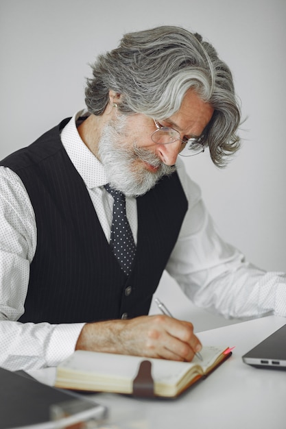 Hombre elegante en la oficina. Hombre de negocios con camisa blanca. El hombre trabaja con un portátil.