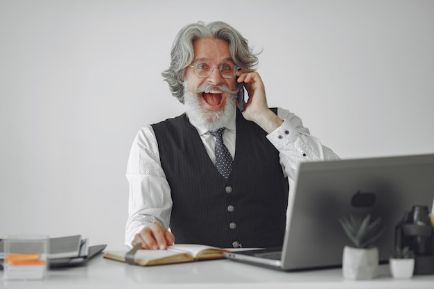 Hombre elegante en la oficina. Hombre de negocios con camisa blanca. El hombre trabaja con el teléfono.