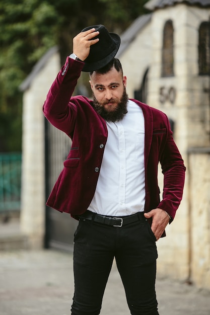 Foto gratuita hombre elegante poniéndose un sombrero