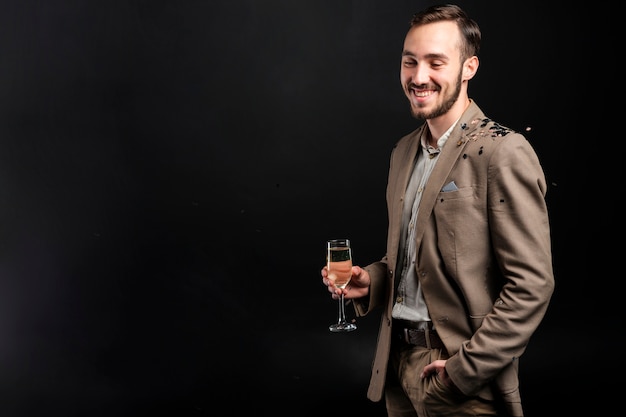 Foto gratuita hombre elegante posando con copa de champán