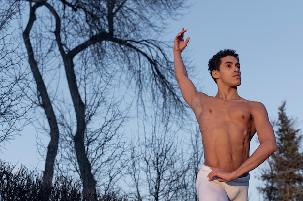 Foto gratuita hombre en elegante posición de ballet en la calle