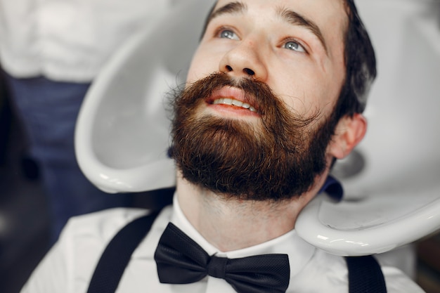 Foto gratuita hombre elegante sentado en una barbería