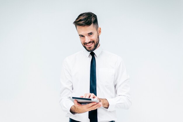 Hombre elegante sonriendo mientras mira una tableta