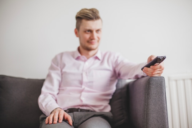 Foto gratuita hombre elegante sujetando un mando a distancia