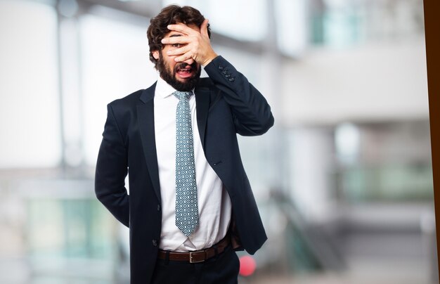 Hombre elegante tapándose los ojos