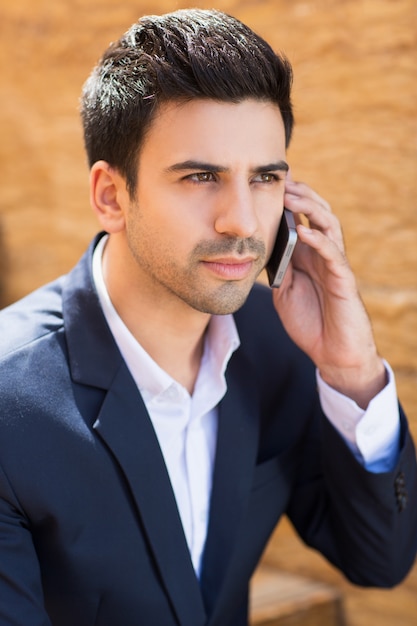 Hombre elegante con un teléfono en la oreja