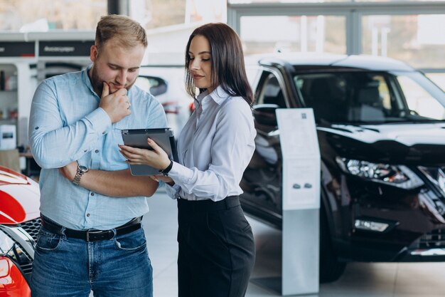 Hombre eligiendo un coche y hablando con el vendedor