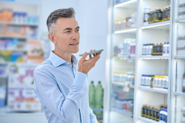 Un hombre eligiendo medicamentos en una farmacia.