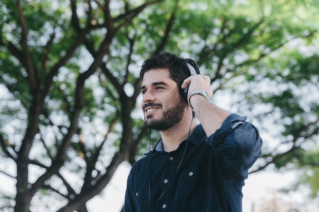 Hombre emocionado en auriculares en el parque