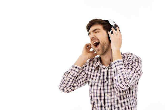 Foto gratuita hombre emocionado cantando en auriculares, disfruta de la música