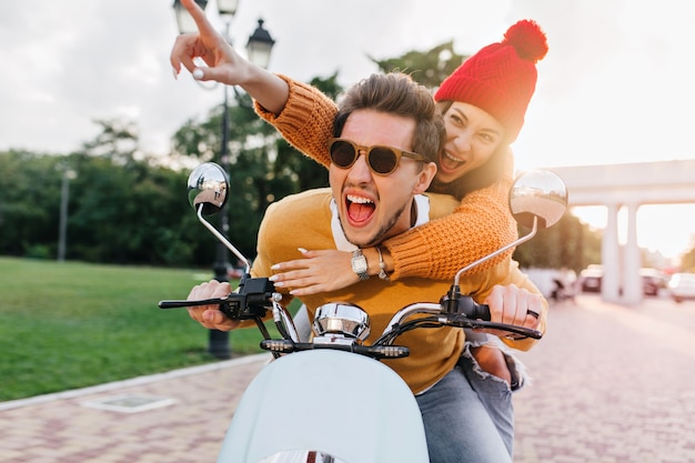 Foto gratuita hombre emocionado con gafas oscuras de moda disfruta de un viaje rápido con un hermoso amigo