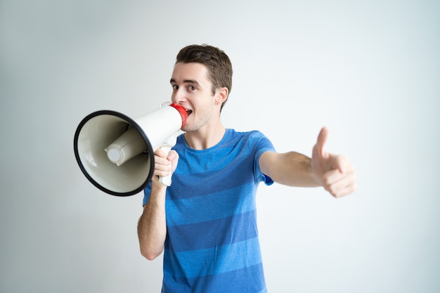 Hombre emocionado hablando en megáfono y apuntándote