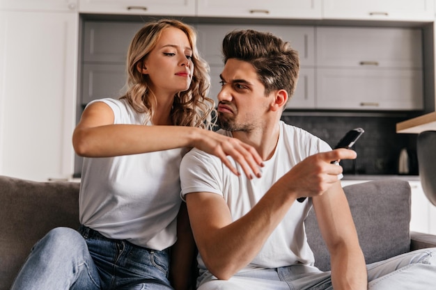 Hombre emocional ver televisión en casa Pareja caucásica sentada en la sala de estar