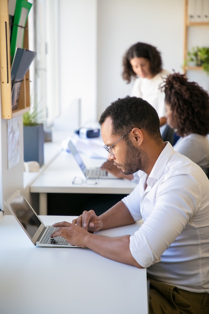 Foto gratuita hombre empleado serio trabajando en proyecto en la oficina