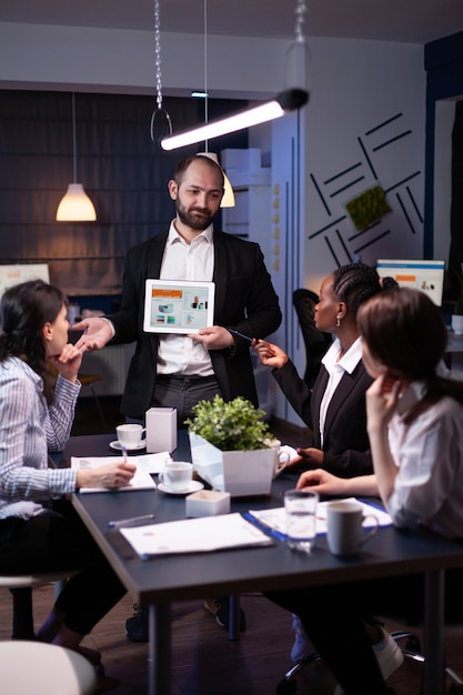 Hombre emprendedor de negocios que presenta las estadísticas de la empresa con tableta para presentación financiera