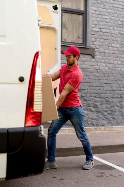 Foto gratuita hombre empujando paquetes en coche