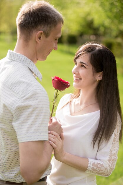 Hombre enamorado dando una rosa a su novia