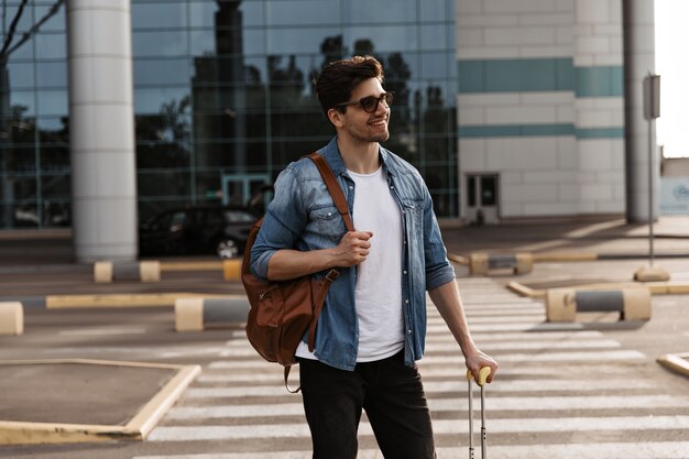 Hombre encantador en gafas de sol sonríe sinceramente