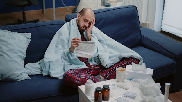 Foto gratuita hombre con enfermedad leyendo folleto de información de medicamentos