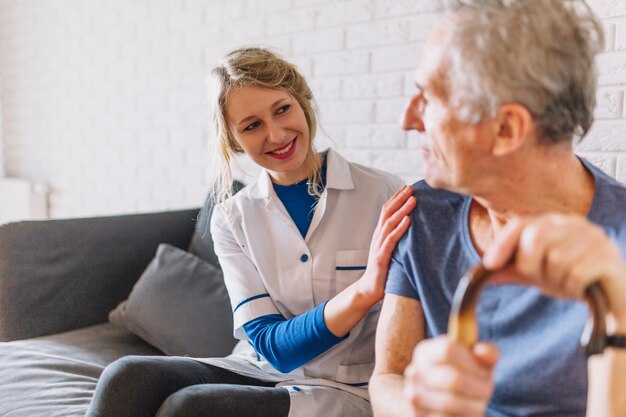 Hombre y enfermera sonriente en asilo de ancianos