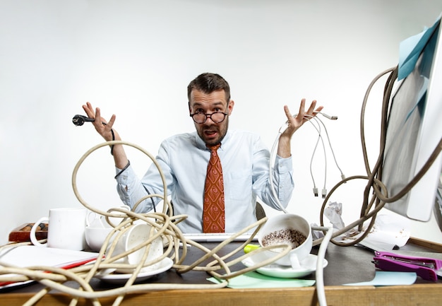 Foto gratuita hombre enojado con cables en su escritorio