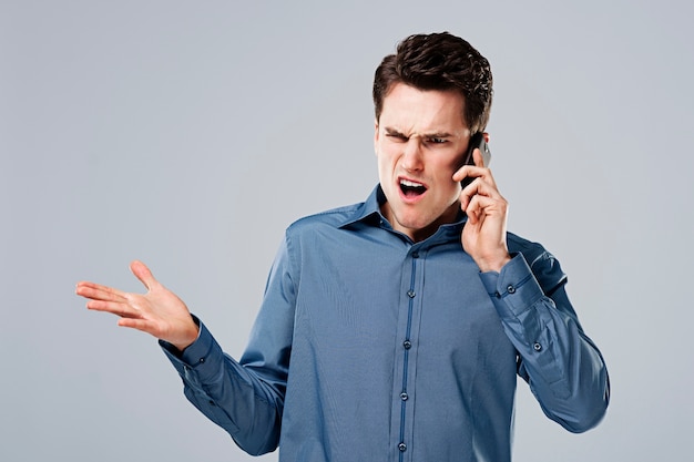 Hombre enojado hablando por teléfono