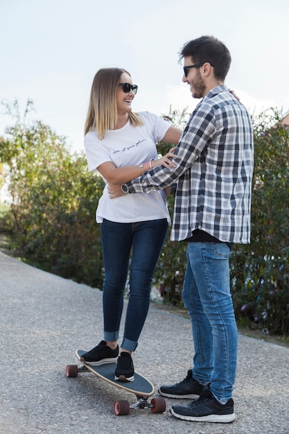 Hombre enseñando a mujer a andar en patineta