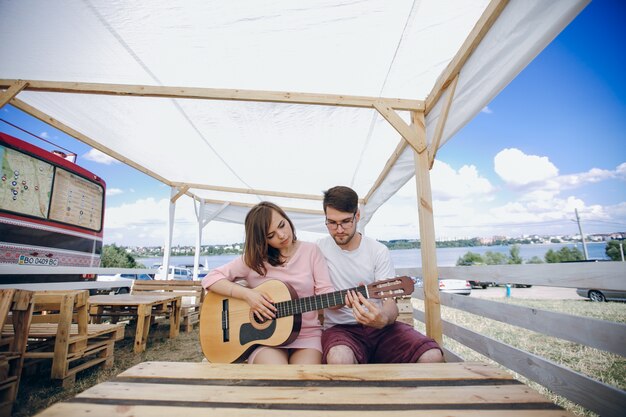 Hombre enseñando a tocar la guitarra a una chica