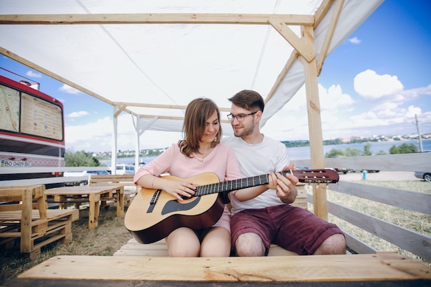 Hombre enseñando a tocar la guitarra a una chica