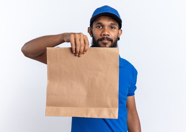 Hombre de entrega afroamericano joven satisfecho con paquete de alimentos aislado sobre fondo blanco con espacio de copia