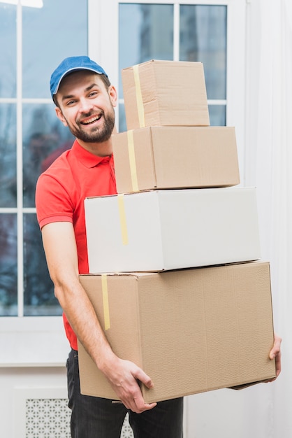 Hombre de entrega alegre con paquetes