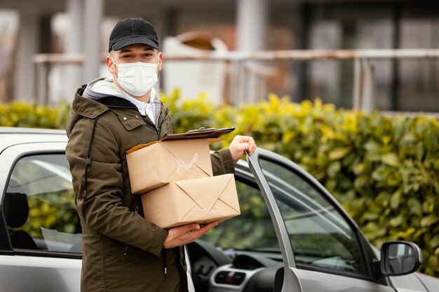 Hombre de entrega con máscara y paquetes