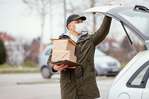 Hombre de entrega con máscara y paquetes