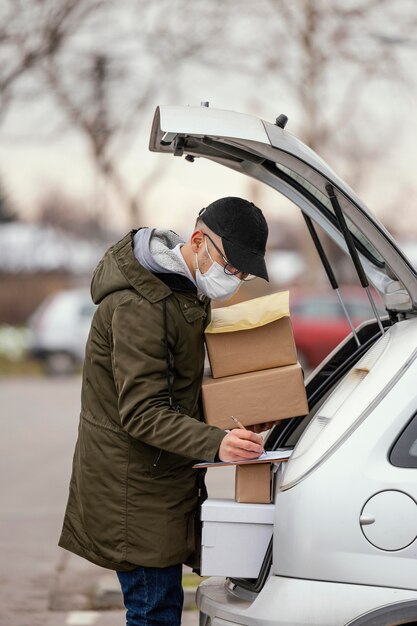 Hombre de entrega con máscara y paquetes