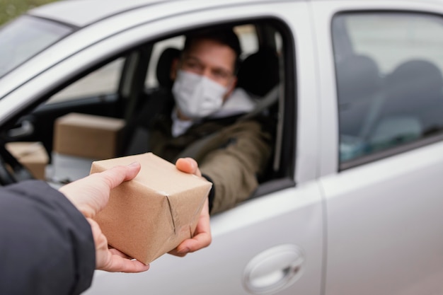 Hombre de entrega con máscara y paquetes