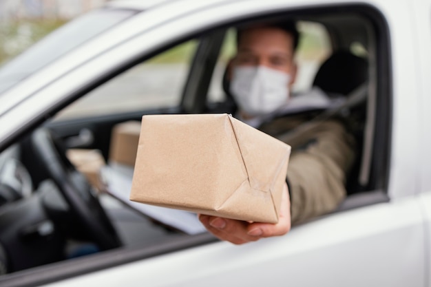 Hombre de entrega con máscara y paquetes