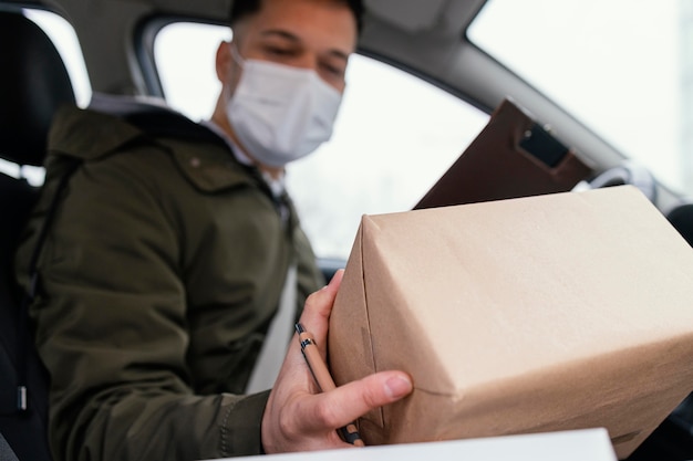 Hombre de entrega con máscara y paquetes