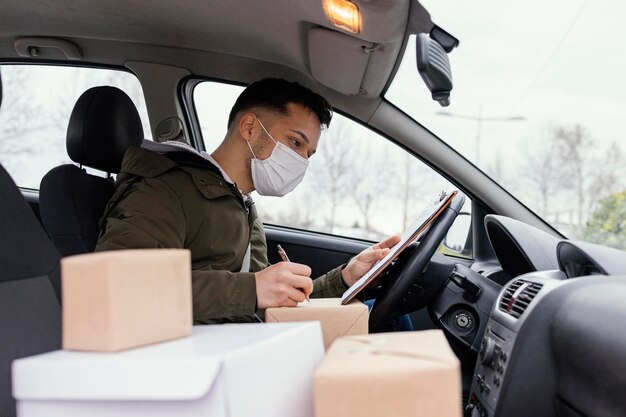 Hombre de entrega con máscara y paquetes