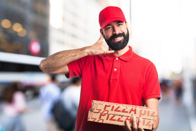 Hombre de entrega de pizza haciendo gesto de teléfono