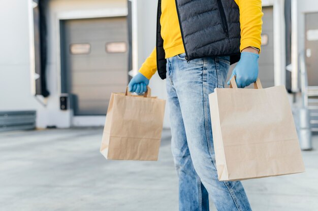 Hombre de entrega de primer plano sosteniendo bolsas de papel