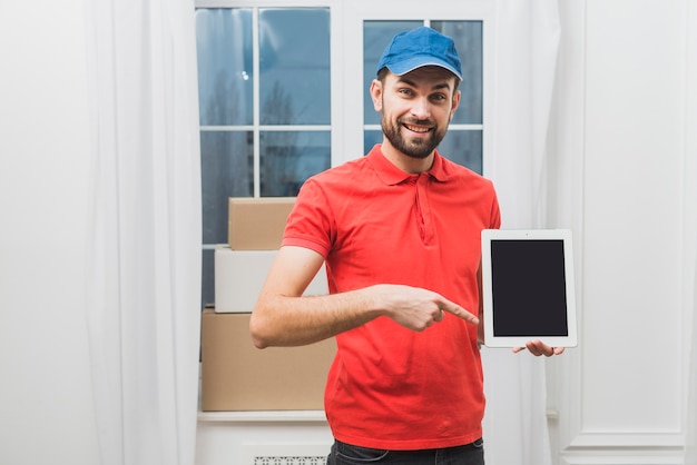 Hombre de entrega que señala en la tableta