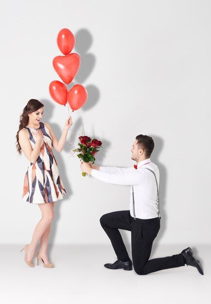 Hombre entregando ramo de rosas a mujer