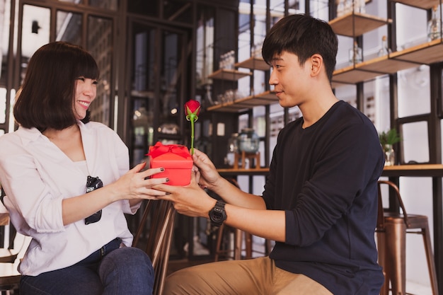 Foto gratuita hombre entregando un regalo a su novia en un restaurante