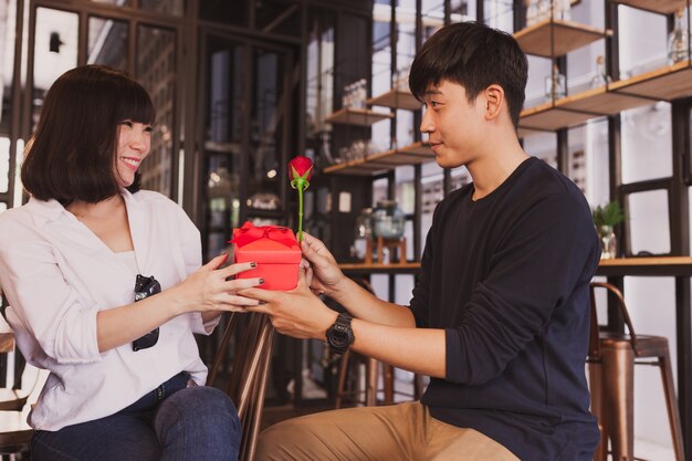 Hombre entregando un regalo a su novia en un restaurante