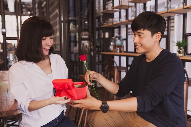 Hombre entregando un regalo a su novia en un restaurante