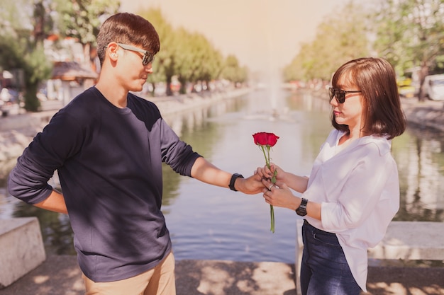 Hombre entregando una rosa a una mujer