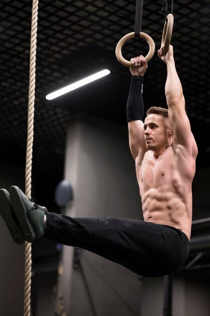 Hombre entrenando en anillos