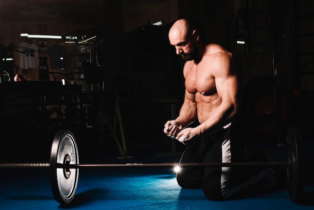 Foto gratuita hombre entrenando con barra en el gimnasio