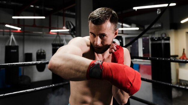 Hombre entrenando en ring de boxeo