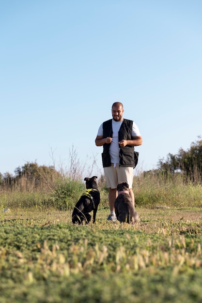 Foto gratuita hombre entrenando a sus dos perros al aire libre